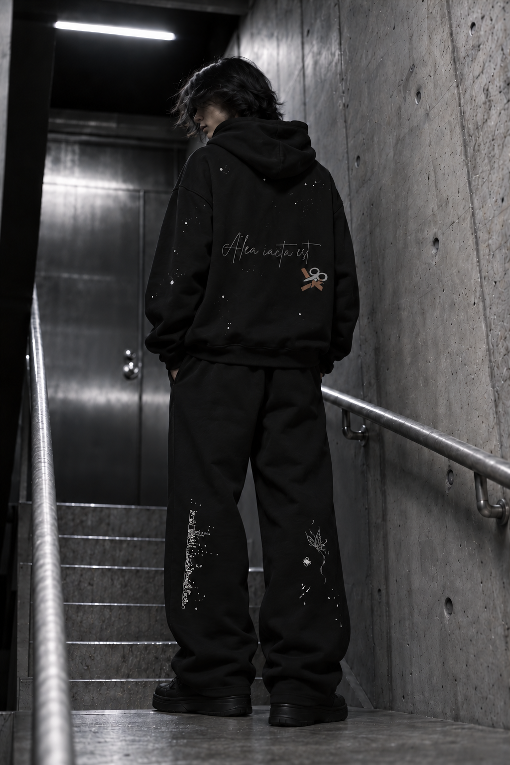 Black hoodie back look in a concrete stairwell
